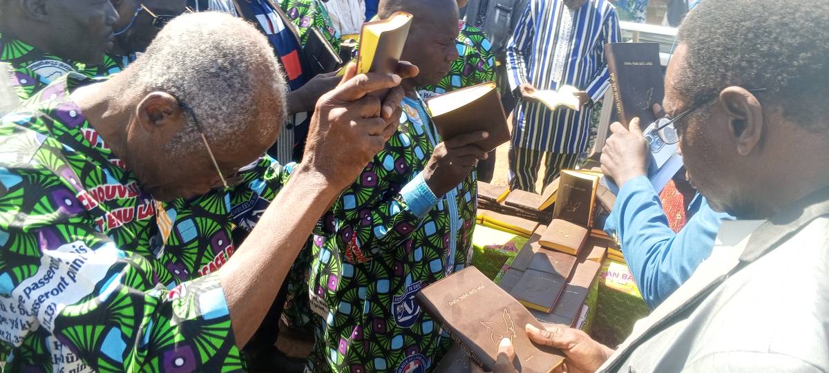 A Buamu Laa community member holding up their New Testament.